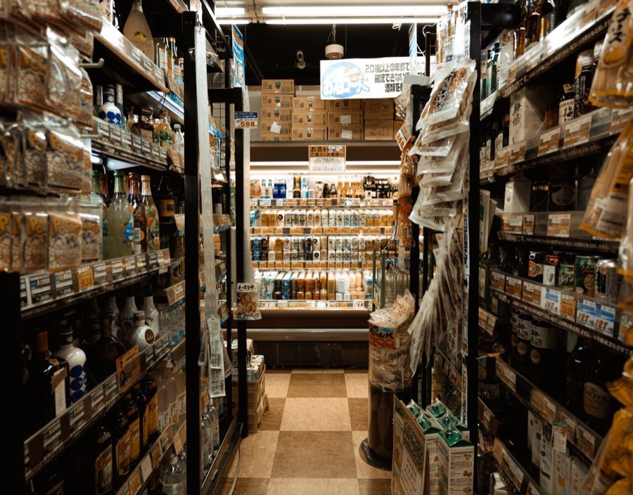 Packed shelves and coolers in a convenience store aisle